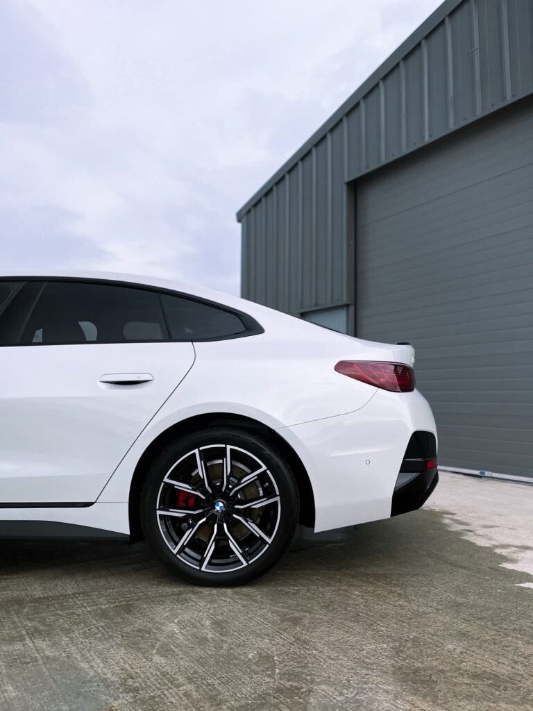 BMW i4 M50 side profile in white showing coupe design